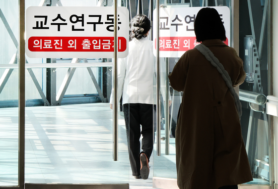 A medical professional walks toward a research lab building in a general hospital in Seoul on Tuesday. [NEWS1]