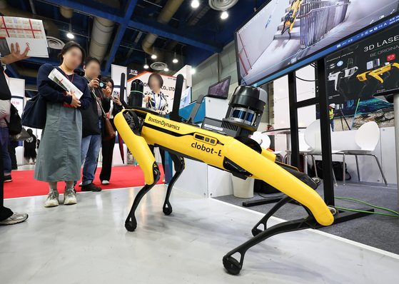Visitors look at a demonstration of a four-legged robot at the Electronics Manufacturing Korea x Automotive World Korea fair held at Coex in Gangnam District, southern Seoul, on Wednesday.[YONHAP]