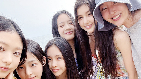 ADOR CEO Min Hee-jin, far right, and girl group NewJeans pose for a selfie while shooting the music video for "Attention" in Spain. [MIN HEE-JIN]