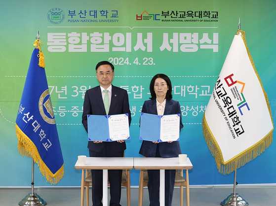 Pusan National University President Cha Jeong-in, left, poses for a photo with Park Soo-ja, president of Busan National University of Education, after signing a memorandum of understanding to open a merged university in March 2027. [PUSAN NATIONAL UNIVERSITY]