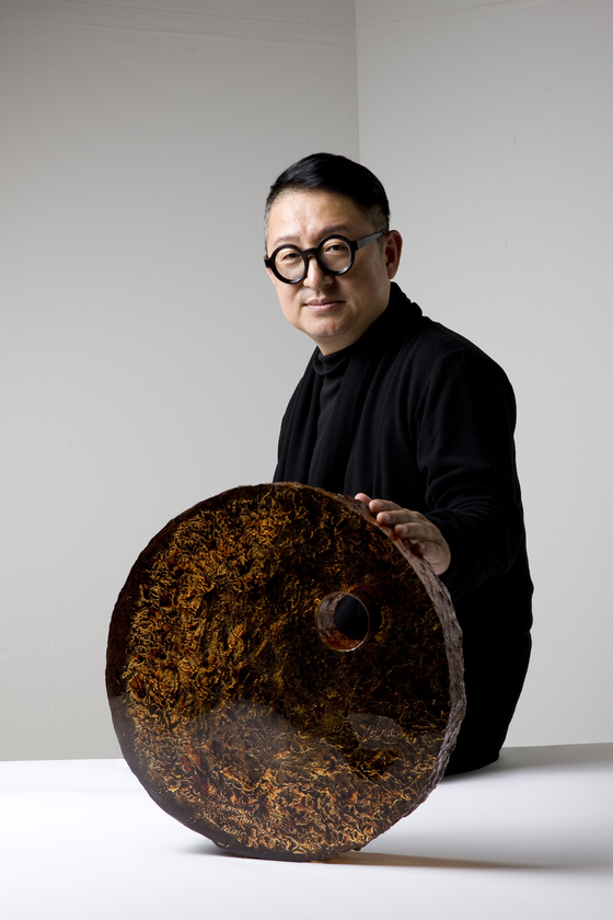 Lee Kyou-hong poses with his glass piece ″Trace of Time″ (2022), which was shortlisted for the Loewe Craft Prize in 2023 [LEE KYOU-HONG]