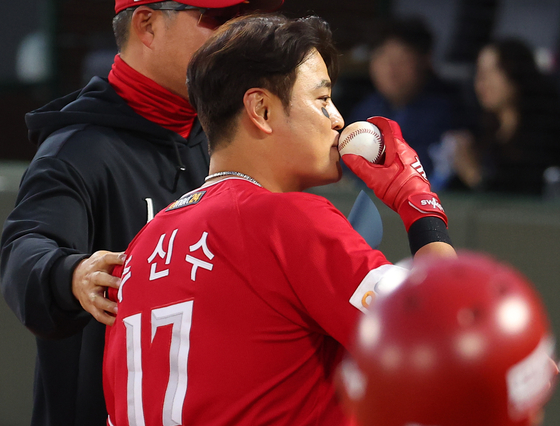 SSG Landers' Choo Shin-soo kisses a baseball after the end of the inning that earned him his 2,000th career hit at Sajik Baseball Stadium in Busan on Wednesday. [YONHAP]