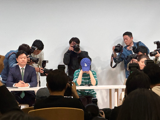 Photo journalists take close-up photos of ADOR CEO Min Hee-jin as she sits down for her press conference Wednesday in southern Seoul. [CHO YONG-JUN]