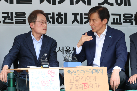 Superintendent of the Seoul Metropolitan Office of Education, Cho Hee-yeon, left, talks to Rebuilding Korea Party leader Cho Kuk, during his protest against the abolition of the student rights ordinance in Jongno District, central Seoul, on Sunday. [YONHAP]