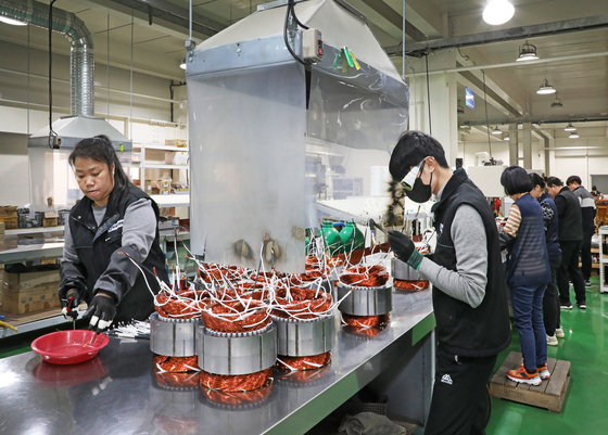 Foreign workers assemble machine parts at Korean motor company GNTECH's factory in Danwon District in Ansan, Gyeonggi, on March 6. [PARK SANG-MOON]