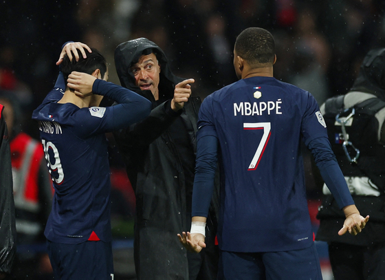 Paris Saint-Germain manager Luis Enrique, center, speaks to Lee Kang-in and Kylian Mbappe before they come on as substitutes at the start of the second half in a match against Le Havre on Saturday at Parc des Princes in Paris. [REUTERS/YONHAP]