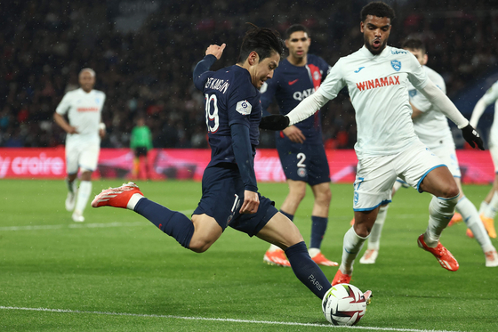Paris Saint-Germain's Lee Kang-in, left, kicks the ball in front of Le Havre's Loic Nego at Parc des Princes in Paris on Saturday. [AFP/YONHAP]