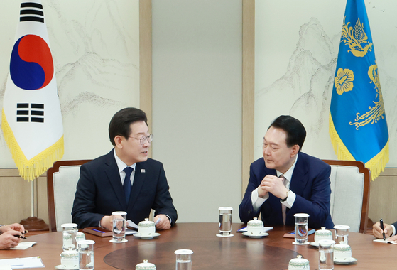 Democratic Party leader Lee Jae-myung, left, speaks to President Yoon Suk Yeol over tea at the presidential office in Yongsan District, central Seoul, on Monday afternoon. [YONHAP]