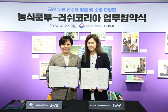 Minister of Agriculture, Food and Rural Affairs Song Mi-ryung, left, and Lush Korea CEO Woo Mi-ryeong, pose for a photo following the signing of a memorandum of understanding aimed at generating new demand and broadening the consumption of domestically produced beans and pulses on Monday. [MINISTRY OF AGRICULTURE, FOOD AND RURAL AFFAIRS] 