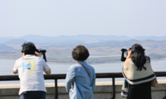 South Koreans peer across the Imjin River into North Korea from an observatory near the inter-Korean border in Paju, Gyeonggi, on April 14. [YONHAP]