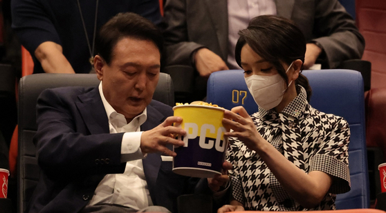 President Yoon Suk Yeol, left, and first lady Kim Keon-hee share a bucket of popcorn at a screening of the movie ″Broker″ at a Megabox movie theater in Seongsu District, eastern Seoul, on May 12, 2022. [NEWS1]