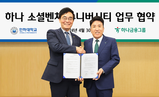 Hana Financial Group Chairman and CEO Ham Young-joo, right, and Inha University President Cho Myeong-woo shake hands during a signing ceremony in Incheon on Tuesday. [HANA FINANCIAL GROUP]