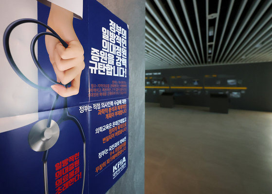 A poster condemning the government's plan to add admissions seats in medical school is attached on the wall inside the headquarters of the Korean Medical Association in Yongsan District, central Seoul on Wednesday. [NEWS1]