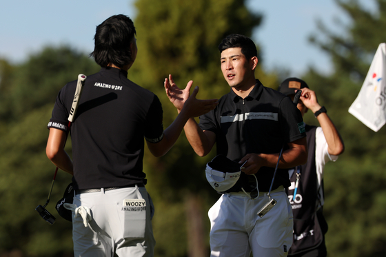 Keita Nakajima of Japan, right, and Min Woo Lee of Australia shake hands after holing out on the ninth green during the second round of the ZOZO Championship at Accordia Golf Narashino Country Club on October 20, 2023 in Inzai, Chiba, Japan. [GETTY IMAGES]