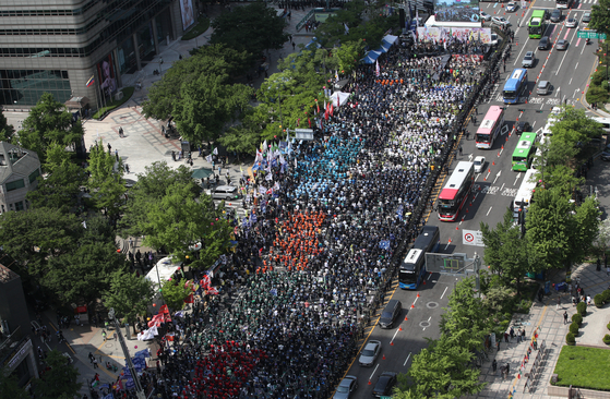 Tens of thousands of labor union members stage a Labor Day rally on Sejong-daero, central Seoul, where governmental agencies and labor authorities are located, demanding improved workers’ rights and labor policies on Wednesday. The protest organizer, the Korean Confederation of Trade Unions, said over 25,000 people participated in the Labor Day rally. [JOINT PRESS CORPS]