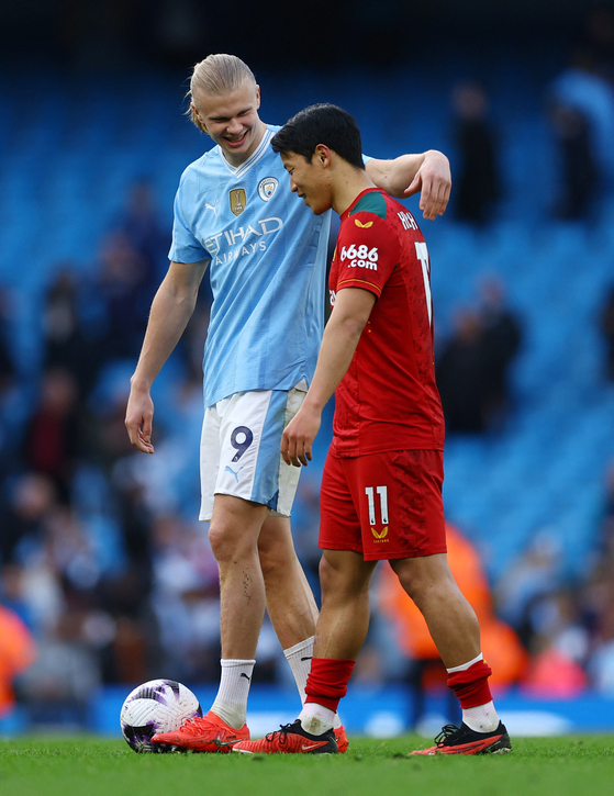 Manchester City's Erling Haaland talks to Wolverhampton Wanderers' Hwang Hee-chan after a game at the Etihad Stadium in Manchester on Saturday.  [REUTERS/YONHAP]