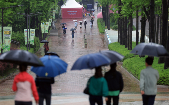 People holding their umbrellas walk through Children's Grand Park on Children's Day in eastern Seoul. [NEWS1]