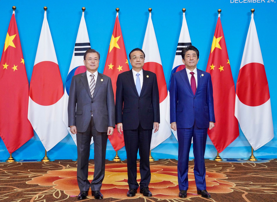 From left, then President Moon Jae-in, former Chinese Premier Li Keqiang and late Japanese Prime Minister Shinzo Abe pose for a photo during a trilateral summit in Cheongdu, China, on Dec. 24, 2019. [YONHAP]