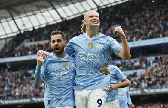 Manchester City's Erling Haaland, right, celebrates with Bernardo Silva after scoring his side's opening goal during a Premier League game against Wolverhampton Wanderers at the Etihad Stadium in Manchester on Saturday.  [AP/YONHAP]