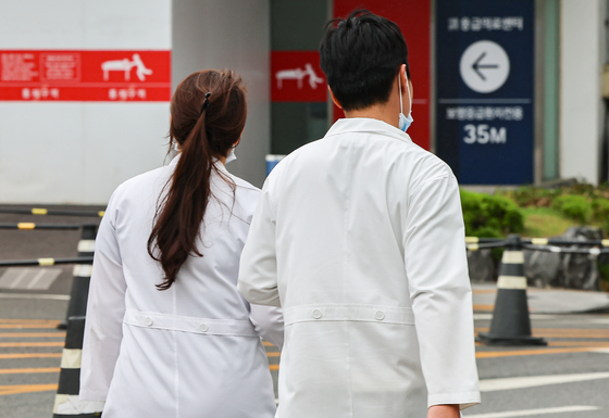 Doctors walk near a hospital in Seoul on Monday. [NEWS1]