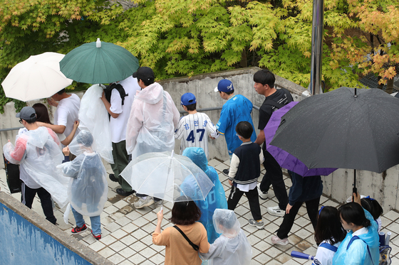 Families leave after the Children's Day game between Lotte Giants and Samsung Lions on Sunday at Samsung Lions Park in Daegu is canceled due to the rain. [NEWS1]