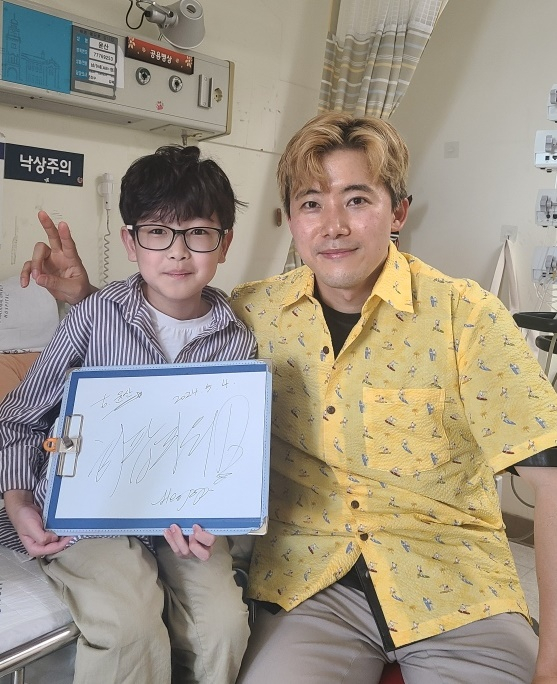 Yoon San, 10, left, meets his role model, the YouTuber Heopop, who made a surprise visit to Seoul National University Hospital in central Seoul on Saturday. [YOON SAN'S FAMILY]