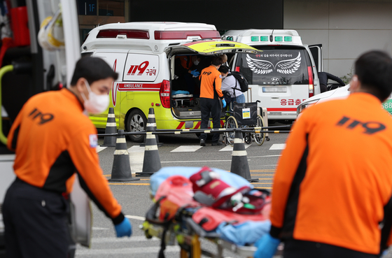 Paramedics transport patients to a general hospital in downtown Seoul on Tuesday. [NEWS1] 