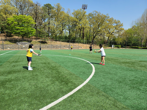 Mary places the ball in the basket after picking it up from the ground. [MARY YANG]