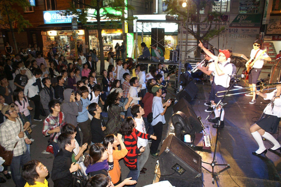 A student band holds a performance near the main gate of Pusan National University in 2008, with traffic being halted. [CHANNEL PNU]