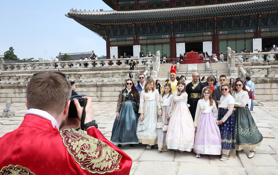 Foreign tourists wearing hanbok, or traditional Korean attire, pose for a photo in front of Gyeongbok Palace in central Seoul on May 1. [YONHAP] 