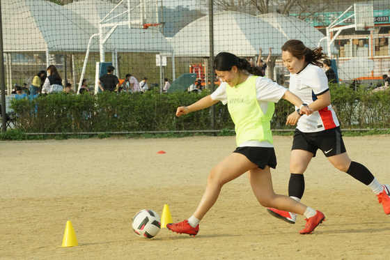 Mary, left, scores her first and, let's be real, only goal of a one-versus-one drill at training with Seoul Calcio FC — and does it with an unfounded amount of glee. [SEOUL CALCIO FC]