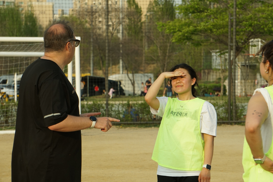 Matteo, left, gives the women's players a post-practice speech while Mary dreams of a snack. [SEOUL CALCIO FC]