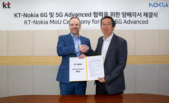 Lee Jong-sik, head of KT's infrastructure digital transformation lab, right, and Ari Kynäslahti, vice president at Nokia, shake hands during a signing ceremony at KT's research and development center in southern Seoul on Wednesday. [KT]