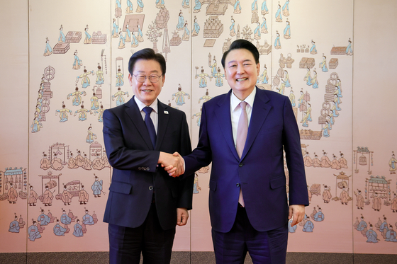 President Yoon Suk Yeol, right, shakes hands with Democratic Party leader Lee Jae-myung in their first official talks at the presidential office in Yongsan District, central Seoul, on April 29. [YONHAP]