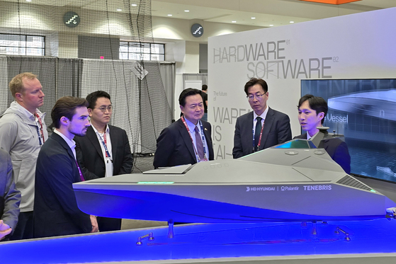 Korean Ambassador to the United States Cho Hyun-dong, center, takes a look at HD Hyundai Heavy Industries' mockup of Tenebris at the AI Expo held in Washington. [HD HYUNDAI]