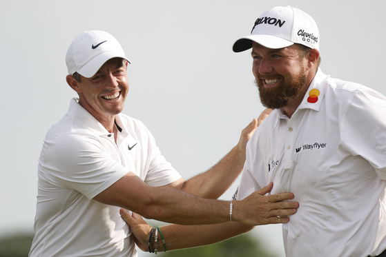Rory McIlroy of Northern Ireland, left, and Shane Lowry of Ireland celebrate the final round of the Zurich Classic of New Orleans at TPC Louisiana in Avondale, Louisiana on April 28. [GETTY IMAGES] 