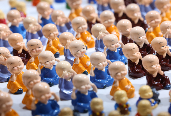 Porcelain statues of young monks are displayed at the Seoul International Buddhism Expo. [YONHAP]