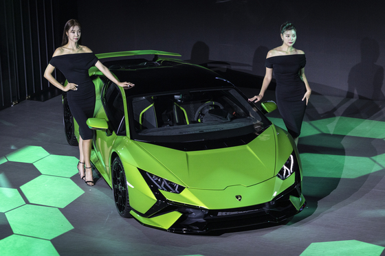 Models pose with the Lamborghini Huracán Tecnica sports car [AUTOMOBILI LAMBORGHINI]