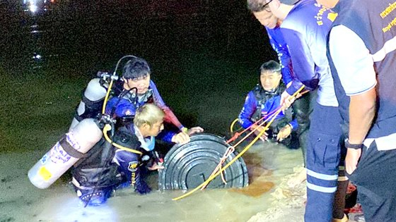 Local police and divers retrieve the body of a Korean tourist in a black plastic barrel filled with cement from a reservoir in Pattaya, Thailand, late Saturday, in a screen capture from Thai news media. [JOONGANG ILBO]