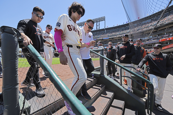 San Francisco Giants' Lee Jung-hoo, third from left, is escorted to the locker room by a trainer after an injury in the first inning of a game against the Cincinnati Reds in San Francisco on Sunday.  [AP/YONHAP]