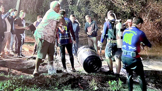 Thai police and divers on Saturday retrieve the body of a Korean tourist suspected to have been hidden in a black plastic barrel that had been submerged in a reservoir in Pattaya, Thailand, in a screen capture from Thai news media. [JOONGANG ILBO]