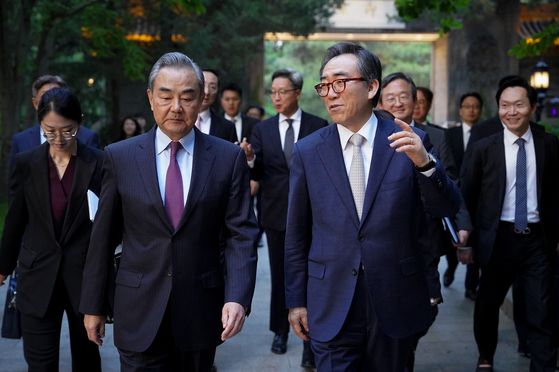 Korean Foreign Minister Cho Tae-yul, right, chats with Chinese Foreign Minister Wang Yi after holding a bilateral meeting at the Diaoyutai State Guesthouse in Beijing Monday. [FOREIGN MINISTRY]