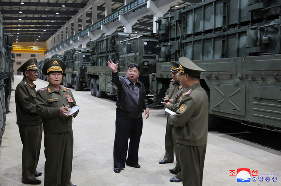 In this photograph released by Pyongyang's state-controlled Korean Central News Agency (KCNA) on Wednesday. North Korean leader Kim Jong-un, center, speaks to military officials during an inspection of an unspecified weapons plant that took place the previous day. [YONHAP]