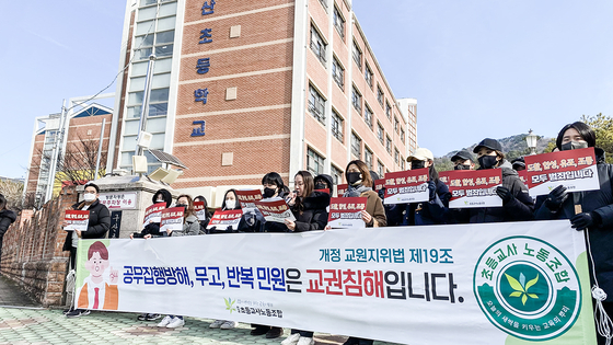 School teachers who are members of a nationwide labor union picket for protections in front of an elementary school on Jan. 25 in Gimhae, South Gyeongsang. [YONHAP] 