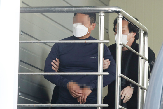 A YouTuber accused of killing a fellow YouTuber in front of Busan District Court in Yeonje Distirct, southeastern Busan, is escorted at Busan Yeonje Police Station. [YONHAP]