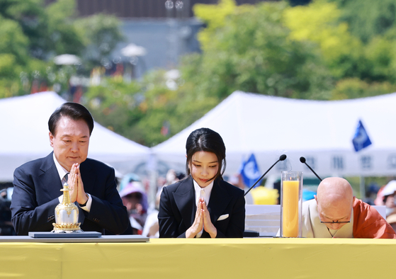 President Yoon Suk Yeol, left, and first lady Kim Keon Hee, center, pray during a ceremony marking the return of rare 14th-century Buddhist relics from the United States to Korea in Yangju, Gyeonggi, on Sunday. [JOINT PRESS CORPS]