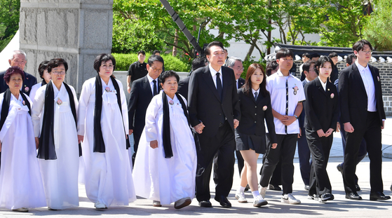 President Yoon Suk Yeol, center, attends a ceremony marking the 44th anniversary of the Gwangju Democratization Movement at the May 18th National Cemetery in Gwangju on Saturday, alongside students and families of victims. He attended the ceremony marking the 1980 pro-democracy uprising in Gwangju for the third consecutive year. [JOINT PRESS CORPS]