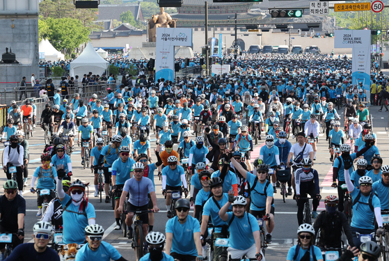 Cyclists cheer as they depart from Gwanghwamun Square in Jongno District, downtown Seoul, Sunday morning for the 2024 Seoul Bike Festival. [JOONGANG ILBO]