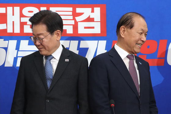 Lee Jae-myung, left, leader of the Democratic Party, and Hwang Woo-yea, interim leader of the People Power Party, head to their seats after exchanging greetings at the National Assembly for their first meeting in Yeouido, western Seoul, on Monday. [NEWS1]