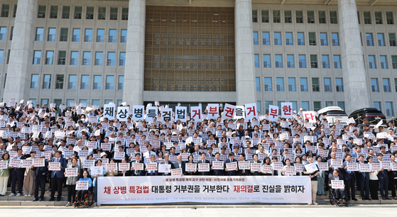 Members of the liberal Democratic Party, the minor Rebuilding Korea Party and various civic groups hold a demonstration in front of the National Assembly on Tuesday afternoon to criticize the president's veto of a bill mandating a special counsel probe into a young Marine's death last year. [YONHAP]